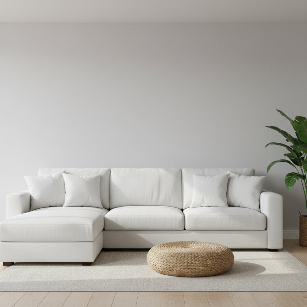 Two framed art prints hanging on a light gray wall above a white sectional sofa. The left print shows a white bird on a muted blue-green background, and the right print shows a sailboat on water.